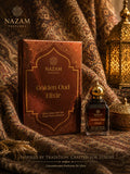 Nazam Perfumes Golden Oud Elixir 25ml premium Arabic attar bottle with a gold dome cap next to its bronze-gold presentation box on a reflective table.