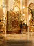 Nazam Perfumes Oud of Valley 25ml premium Arabic attar bottle with a gold dome cap next to its golden paisley presentation box on a reflective marble table.
